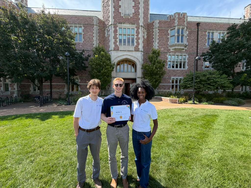 Three students pose with certificate 