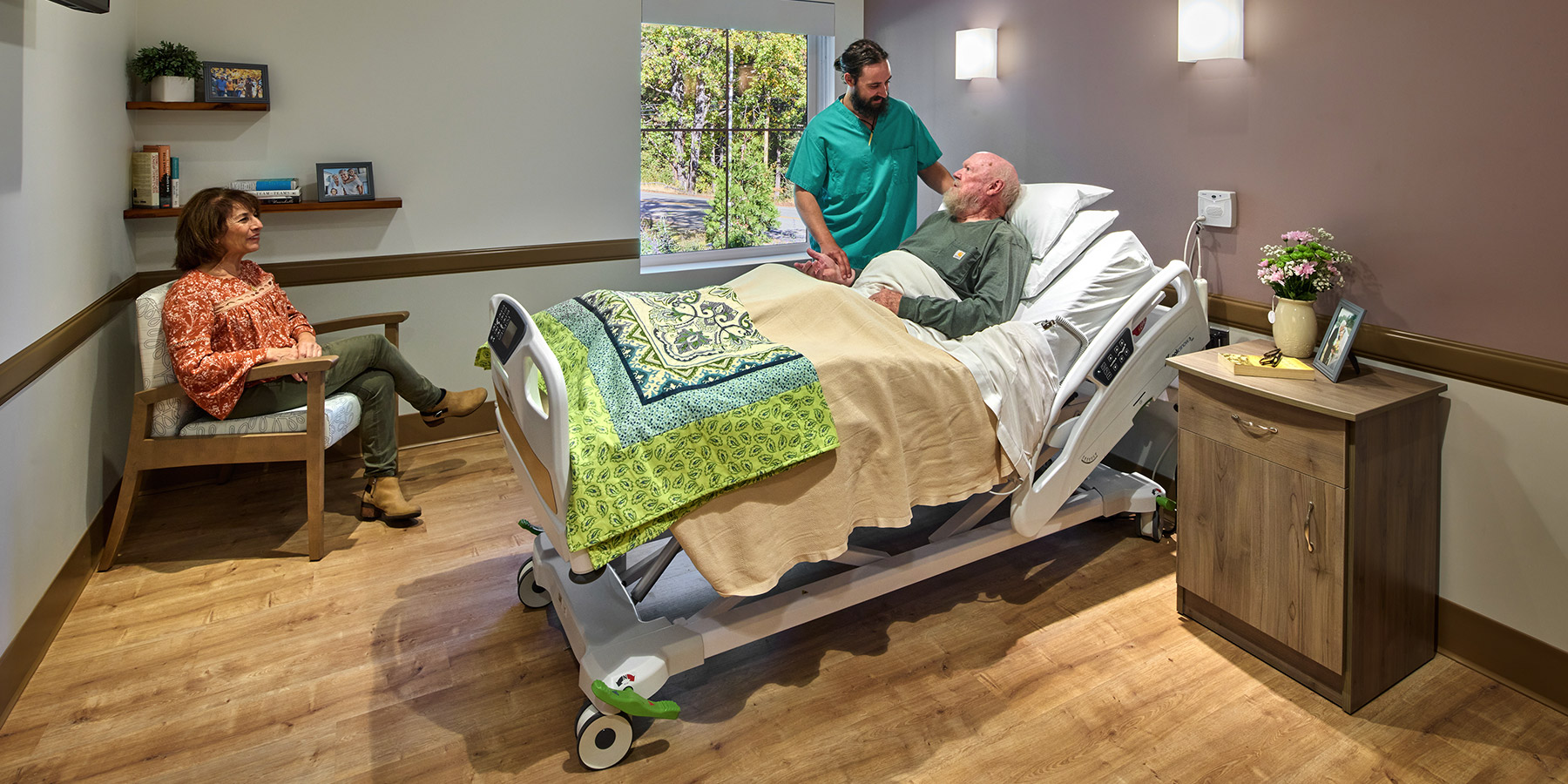 Photo of PDH Skiled Nursing Facility Staff Checking on a Patient
